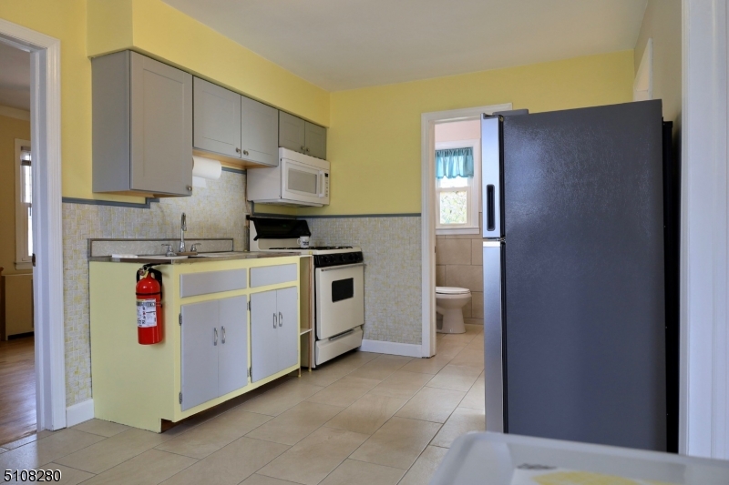 159 Prospect Street, Unit 2 Garfield, NJ 07026 - Photo 7 of 13 a kitchen with stainless steel appliances a refrigerator sink and cabinets
