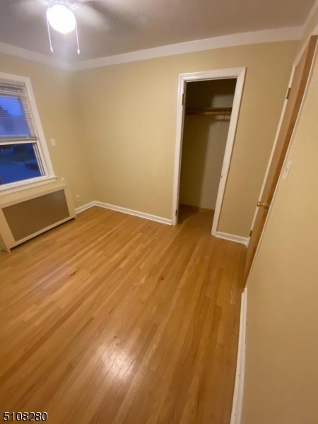 159 Prospect Street, Unit 2 Garfield, NJ 07026 - Photo 9 of 13 a view of an empty room with wooden floor and a window
