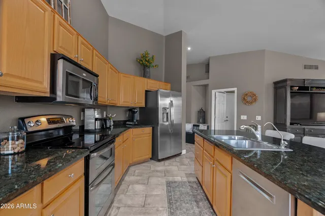 a kitchen with stainless steel appliances granite countertop a sink stove and refrigerator