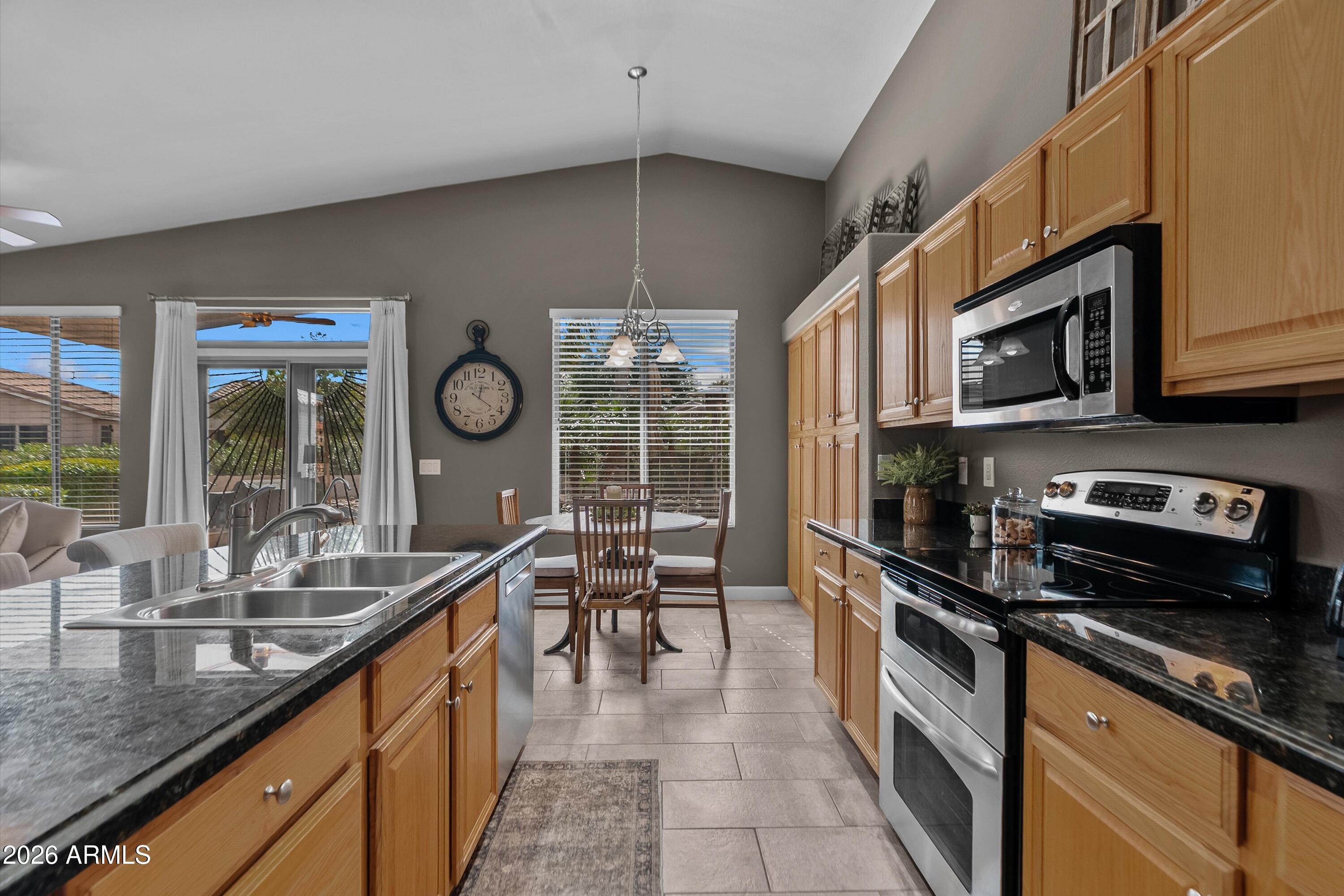 4685 East Walnut Road Gilbert, AZ 85298 - Photo 13 of 58 a kitchen with stainless steel appliances a sink a stove and cabinets