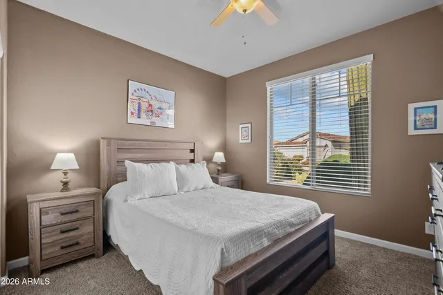 a bedroom with a bed and a flat screen tv in white walls