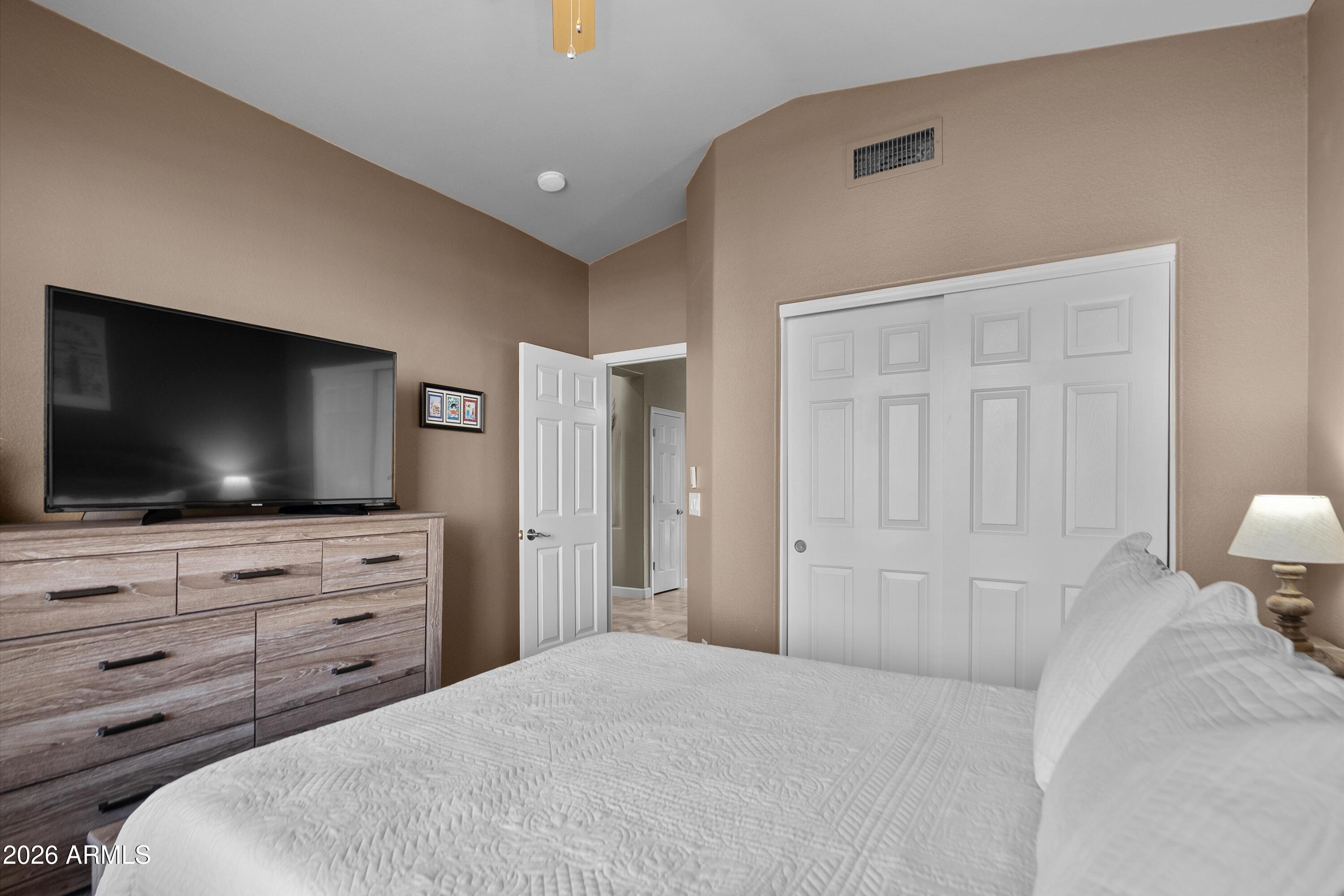 4685 East Walnut Road Gilbert, AZ 85298 - Photo 26 of 58 a bedroom with a bed and a flat screen tv in white walls