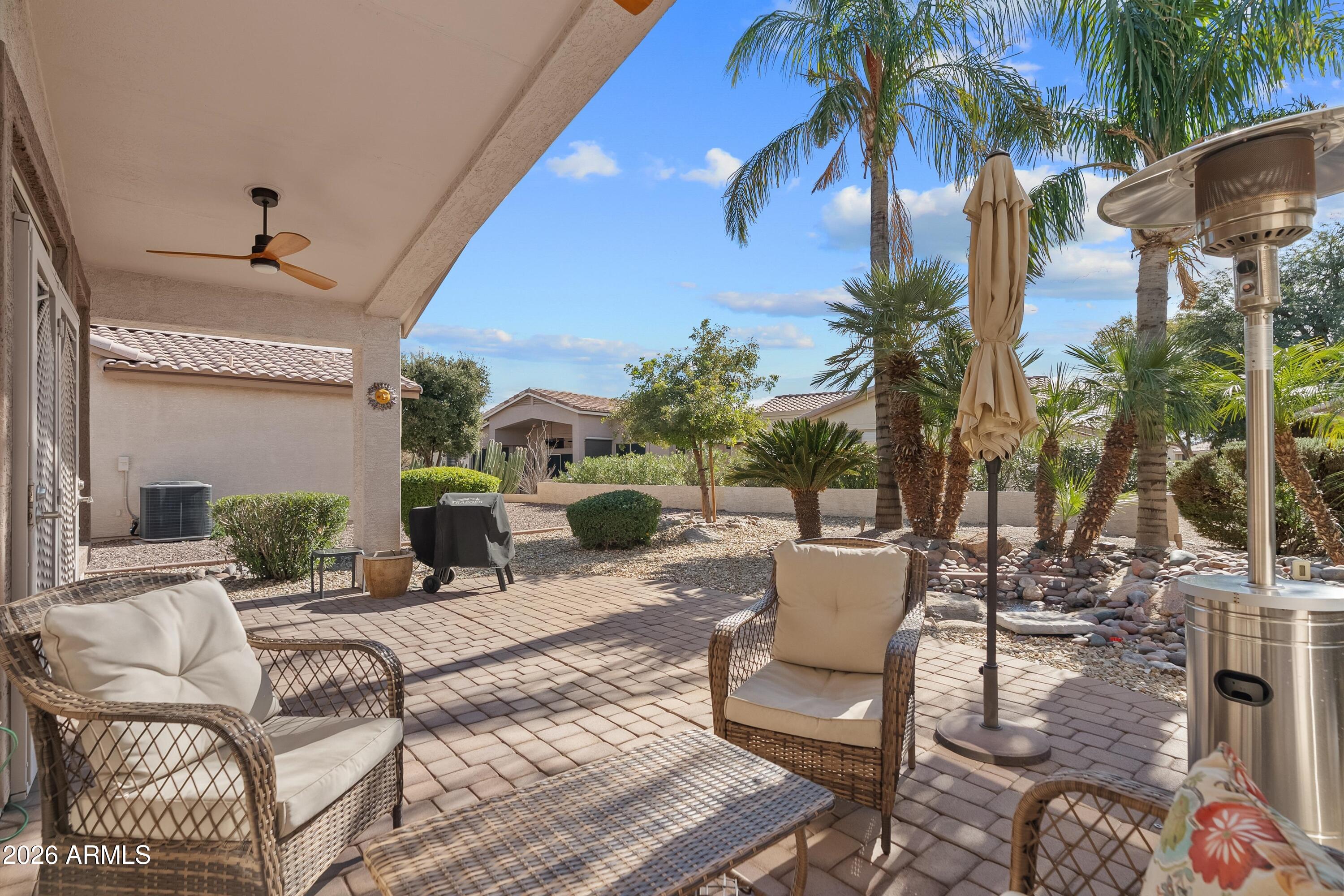4685 East Walnut Road Gilbert, AZ 85298 - Photo 34 of 58 a view of a patio with a dining table and chairs under an umbrella