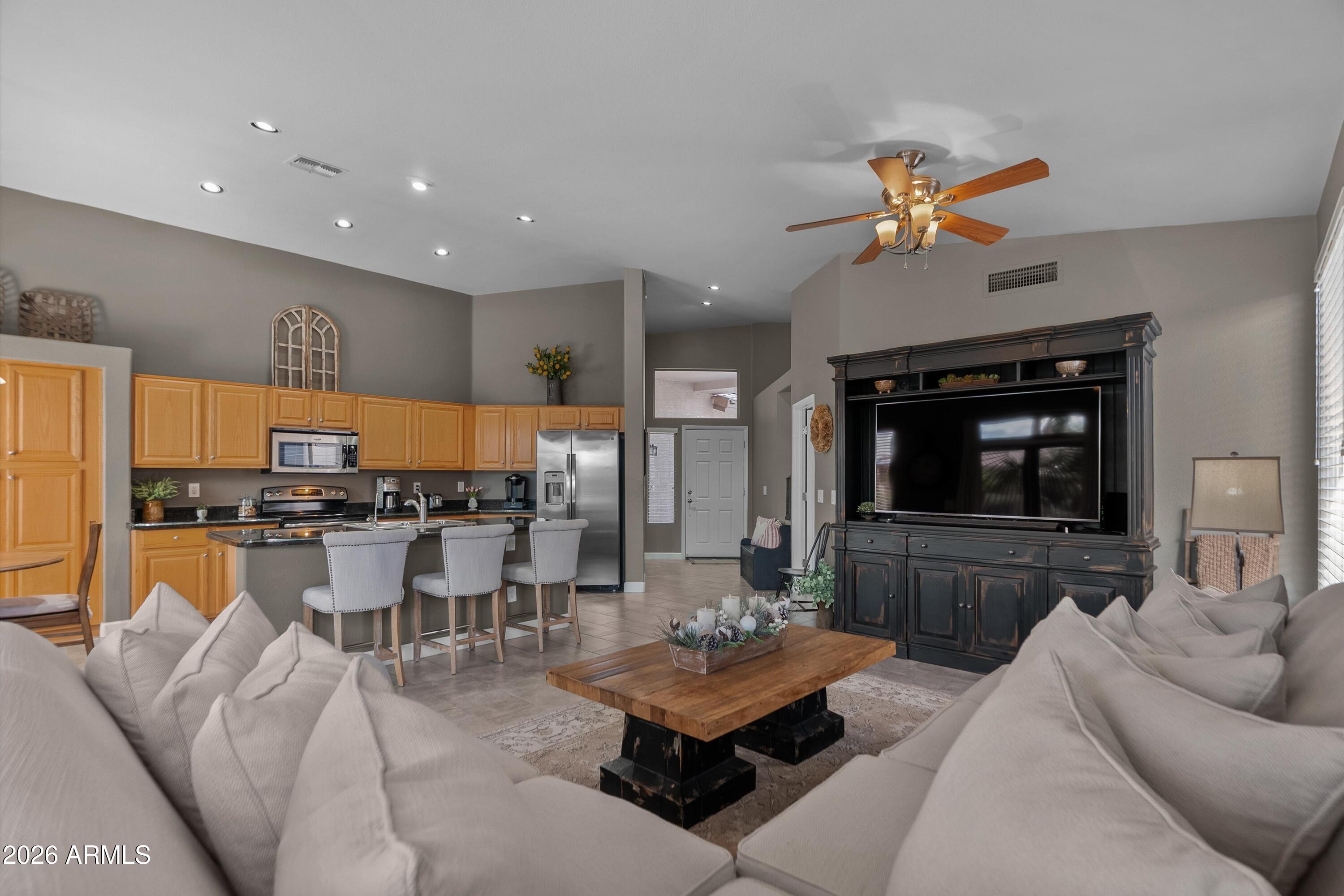 4685 East Walnut Road Gilbert, AZ 85298 - Photo 5 of 58 a living room with furniture a flat screen tv and kitchen view