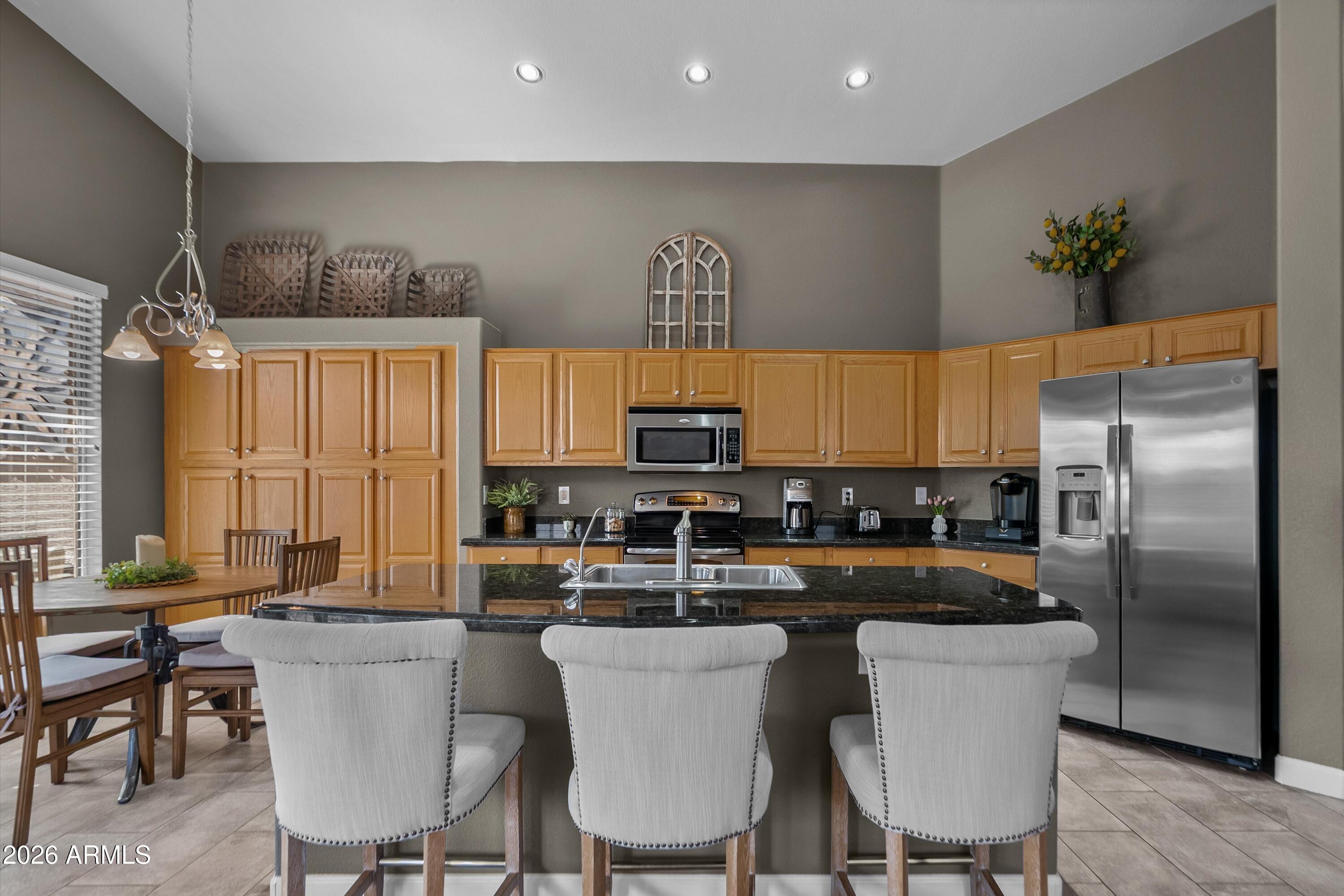 4685 East Walnut Road Gilbert, AZ 85298 - Photo 9 of 58 a kitchen with a table chairs refrigerator and microwave