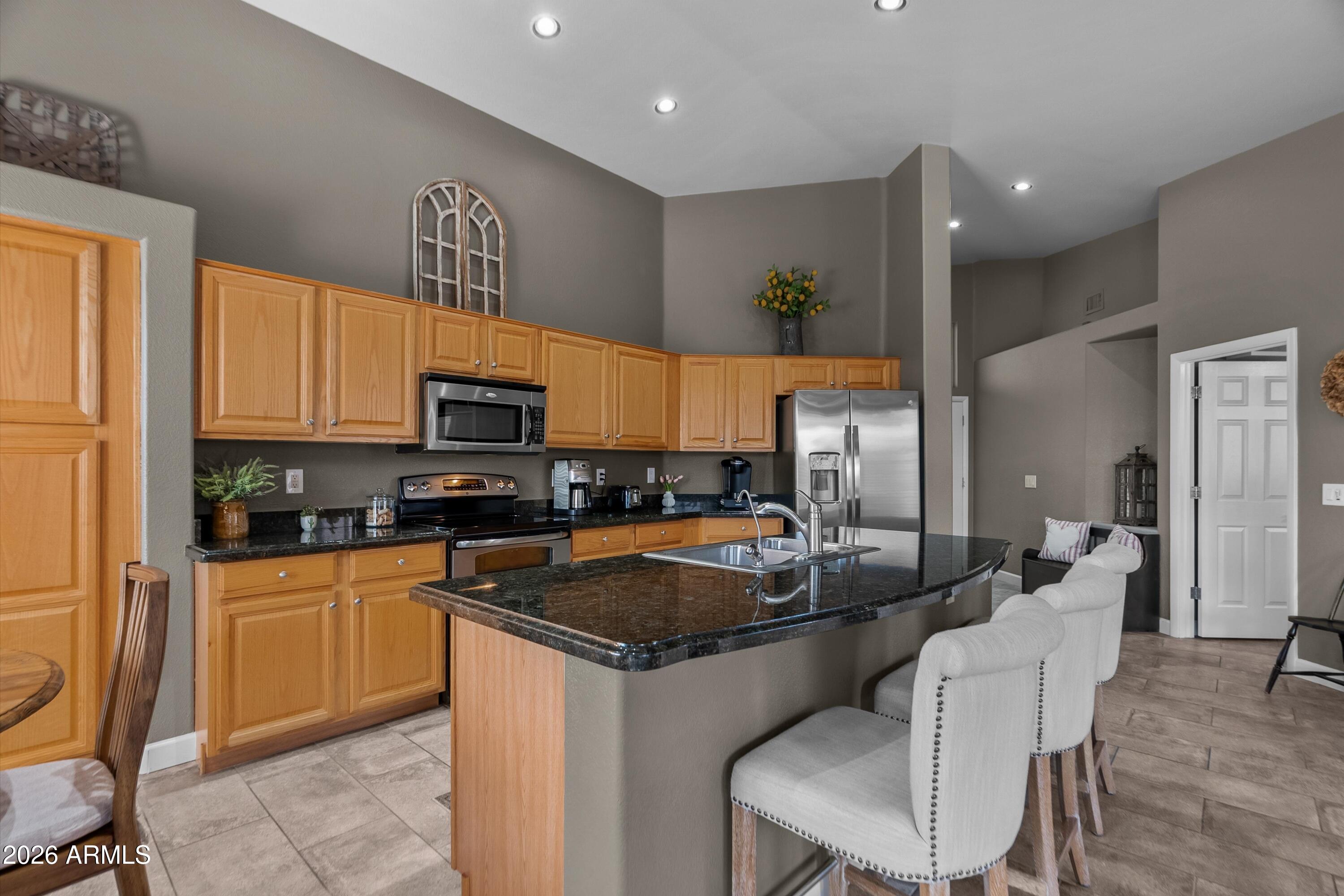 4685 East Walnut Road Gilbert, AZ 85298 - Photo 10 of 58 a kitchen with granite countertop a sink stainless steel appliances and cabinets