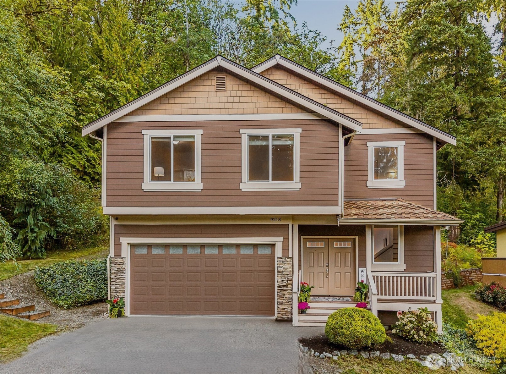 a front view of a house with a garden and garage