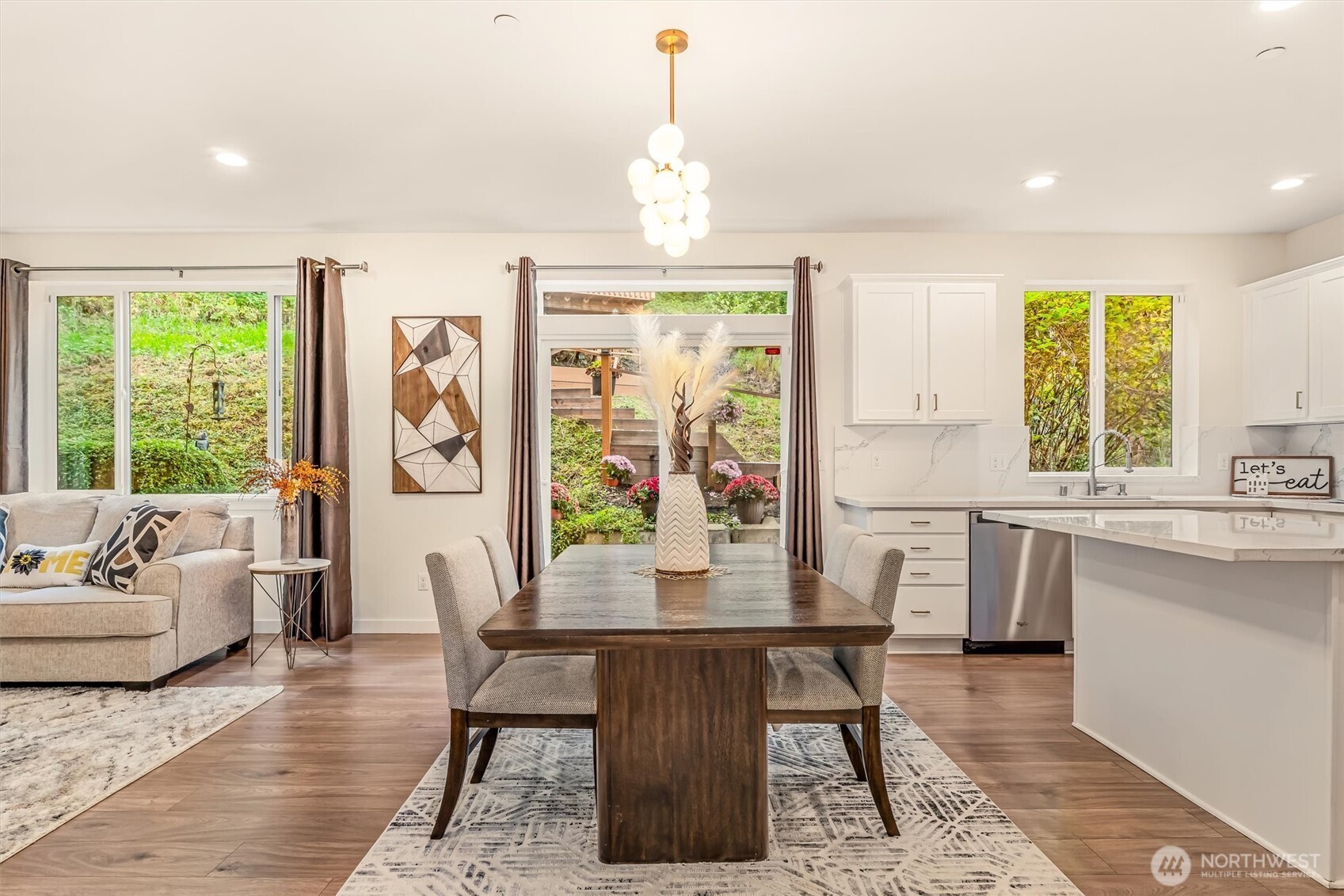 9213 Odin Way Bothell, WA 98011 - Photo 16 of 40 a dining room with furniture a chandelier and wooden floor