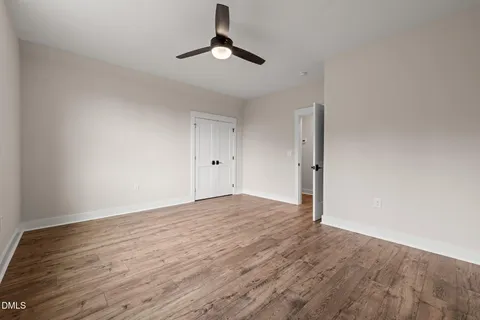 a view of empty room with wooden floor