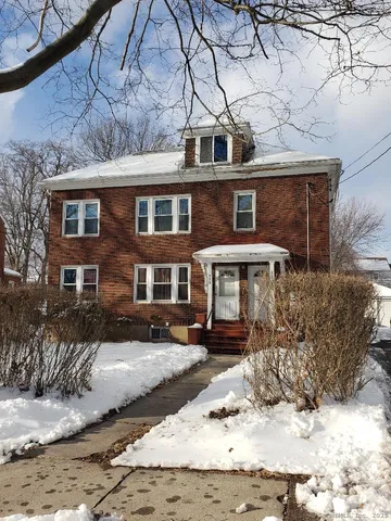 a front view of a house with a yard covered with snow in front of house