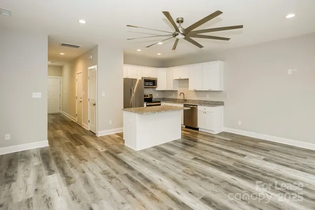 a view of a kitchen with a sink a microwave and cabinets
