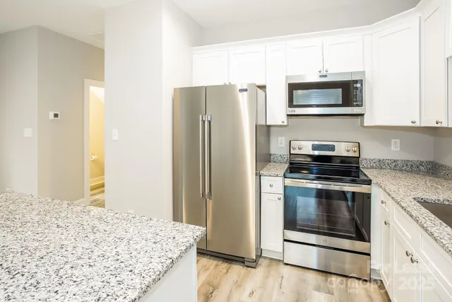 a kitchen with stainless steel appliances granite countertop a refrigerator stove and microwave