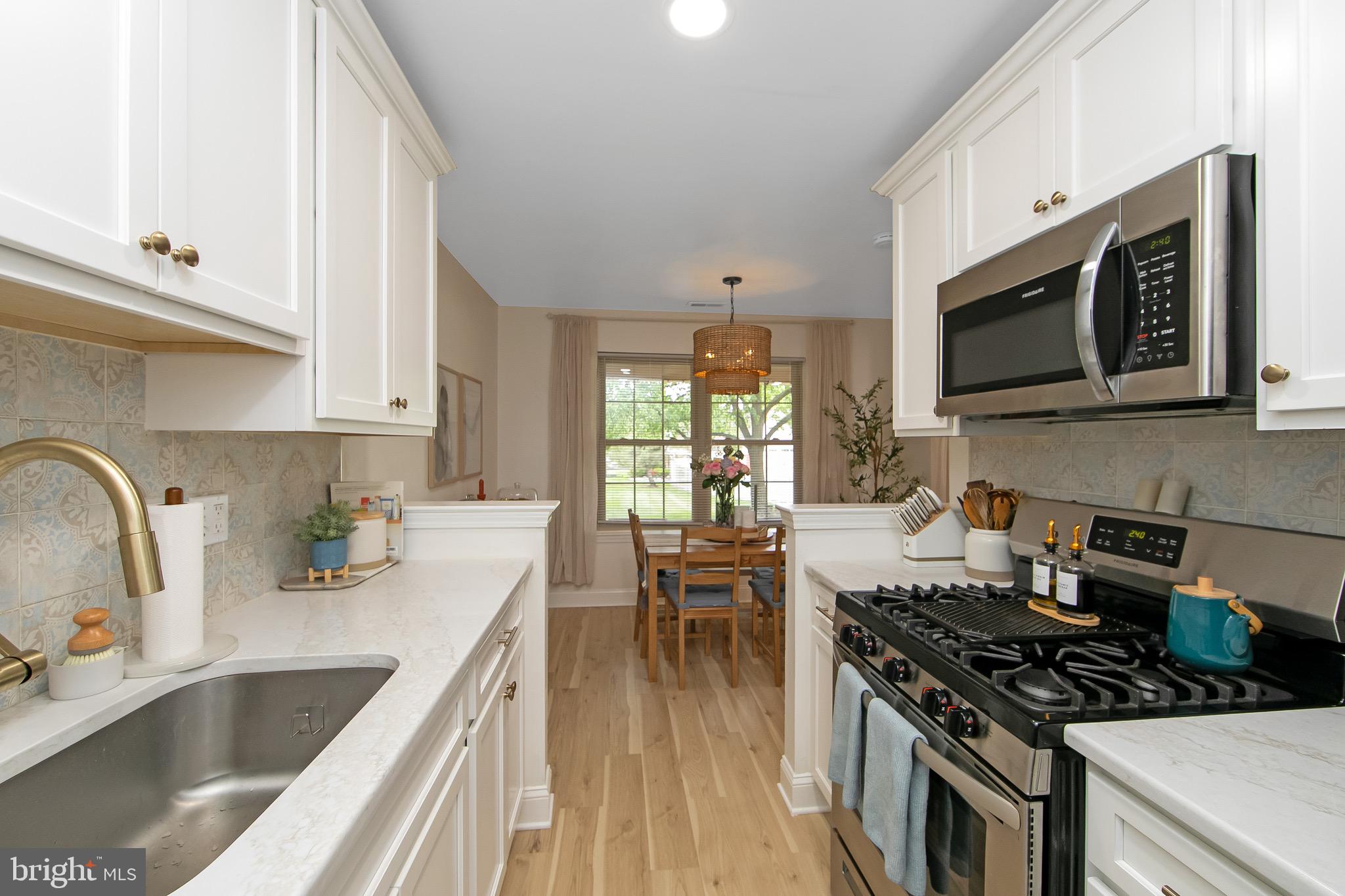 166 Tavistock Cherry Hill, NJ 08034 - Photo 11 of 38 a kitchen with stainless steel appliances a stove sink microwave and cabinets