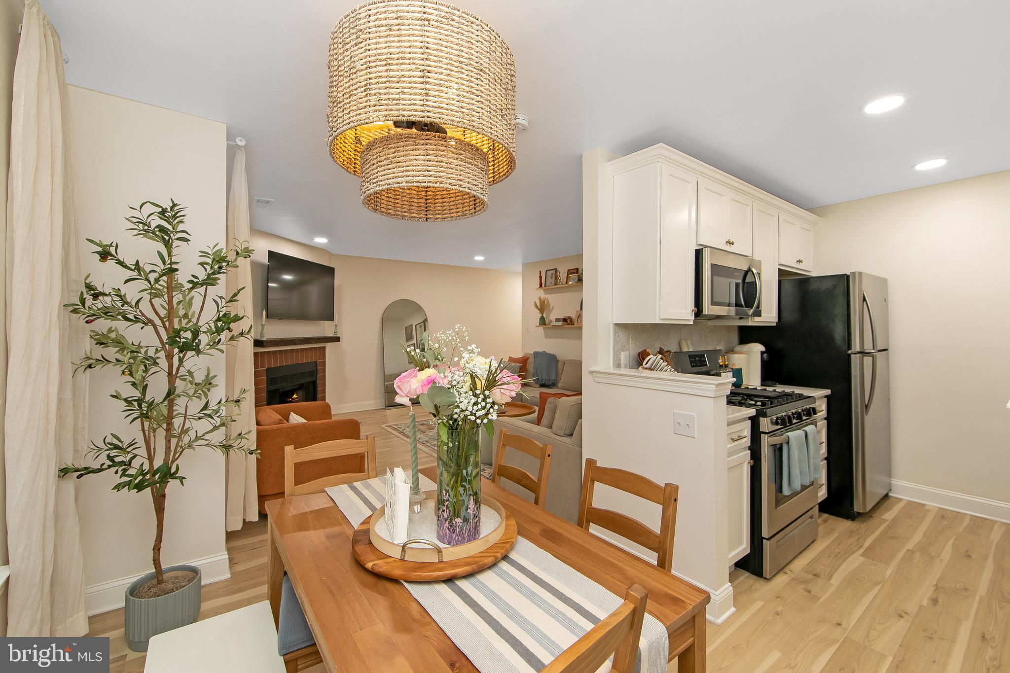 166 Tavistock Cherry Hill, NJ 08034 - Photo 14 of 38 a kitchen with stainless steel appliances a dining table a stove a microwave a refrigerator and cabinets