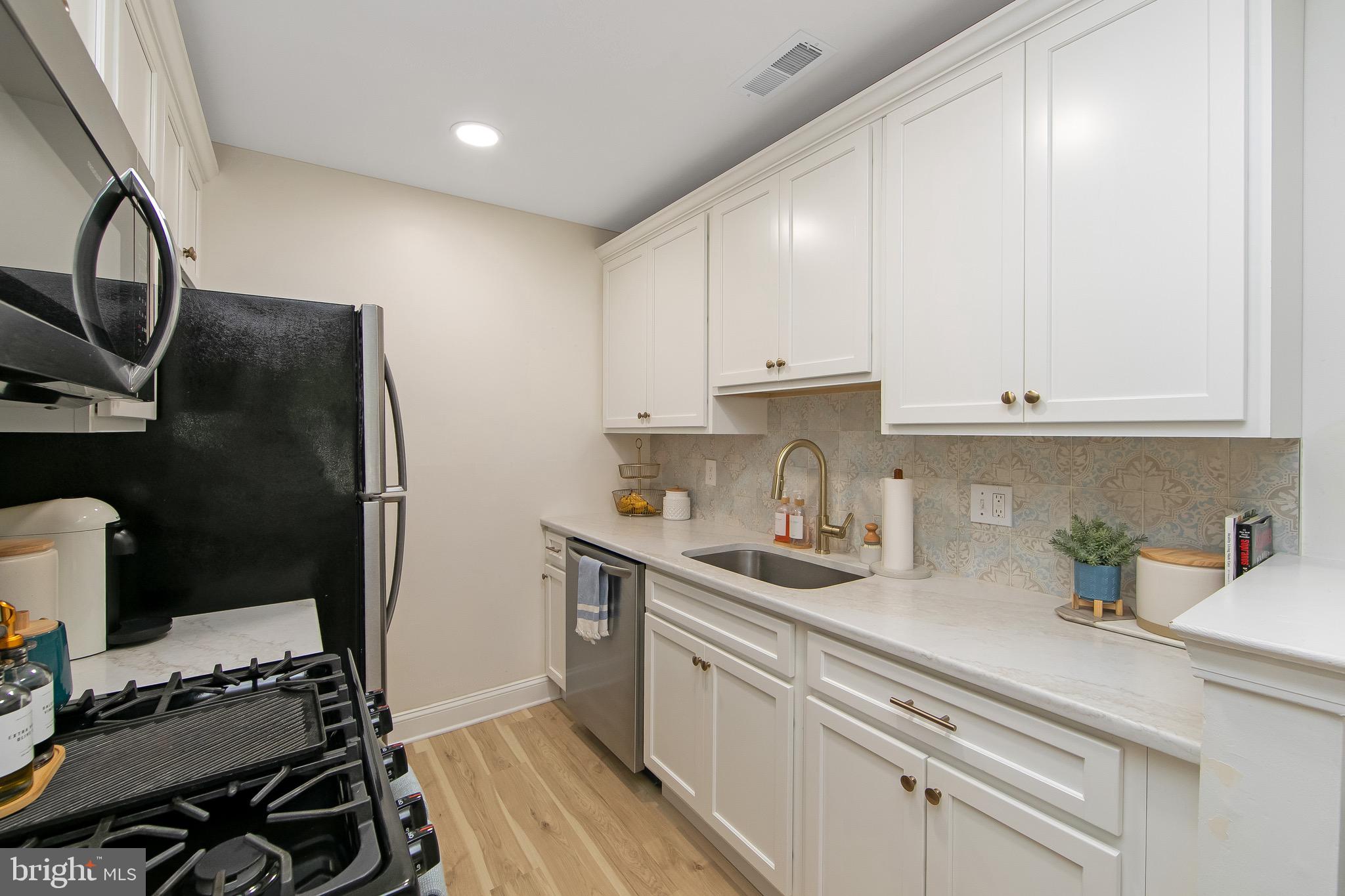 166 Tavistock Cherry Hill, NJ 08034 - Photo 9 of 38 a kitchen with stainless steel appliances a sink stove and cabinets
