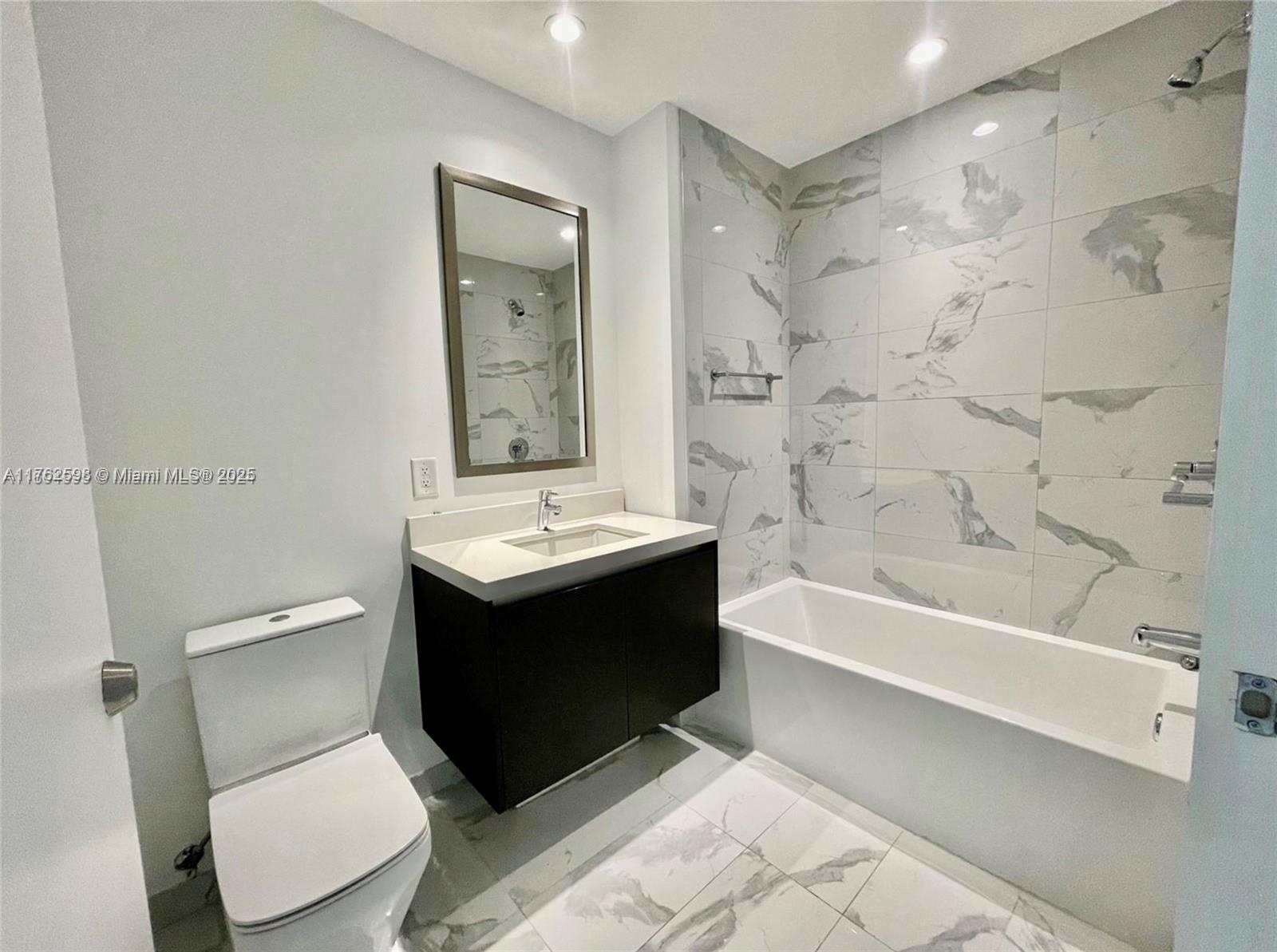 851 Northeast 1st Avenue, Unit 904 Miami, FL 33132 - Photo 6 of 14 a bathroom with a sink toilet and shower