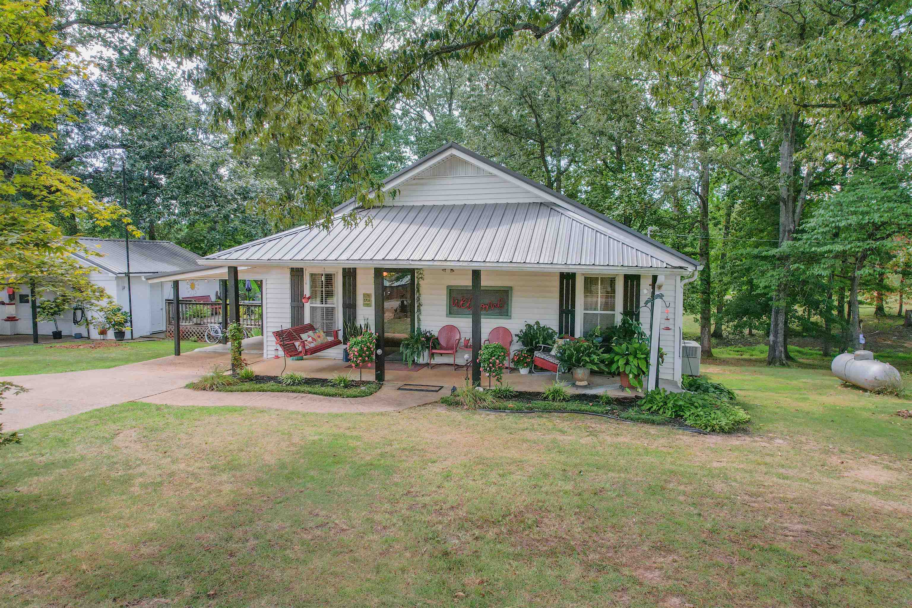 264 Good Hope Church Road Adamsville, TN 38310 - Photo 1 of 1 View of front of home with covered porch, a front yard, an attached carport, concrete driveway, and a metal roof