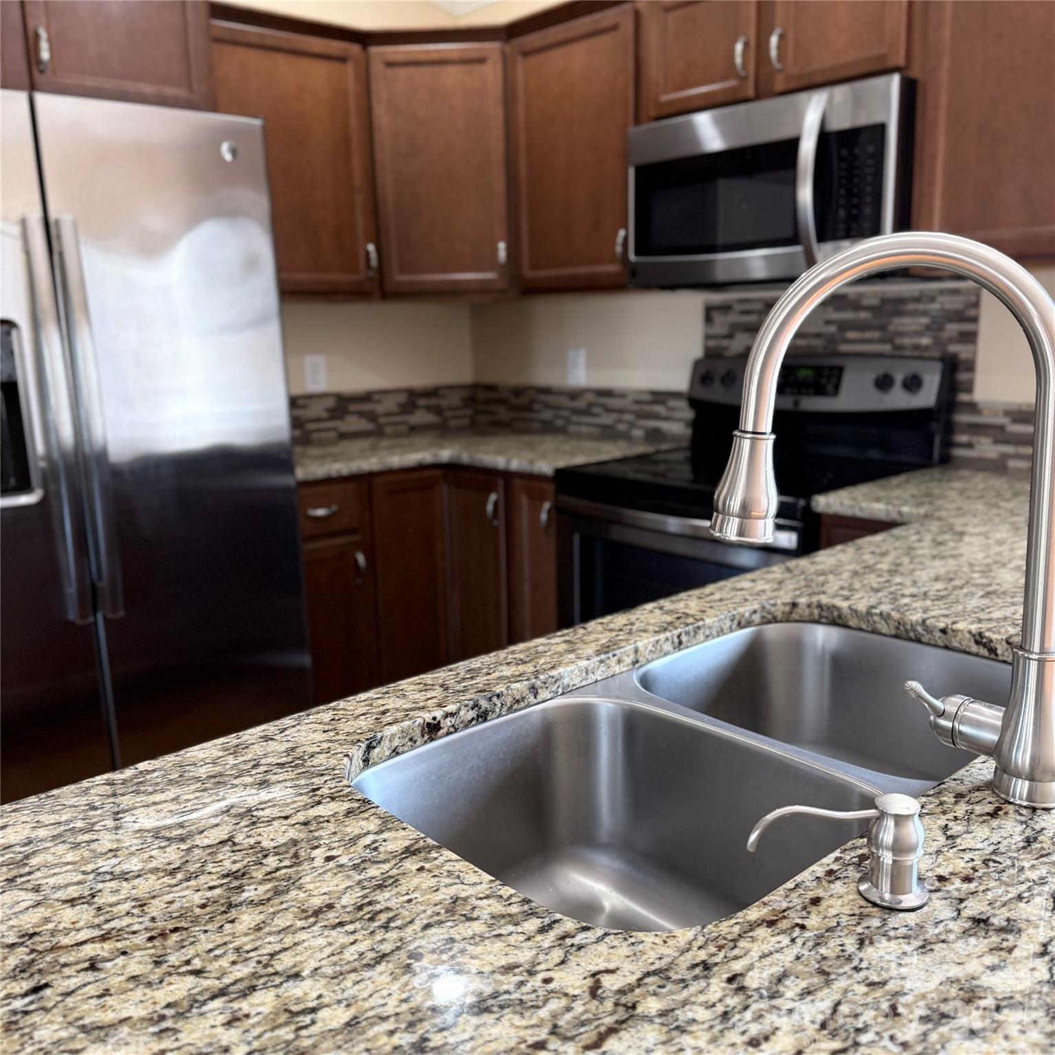 3523 Icard Rhodhiss Road Connelly Springs, NC 28612 - Photo 7 of 28 a kitchen with stainless steel appliances granite countertop a sink stove and refrigerator