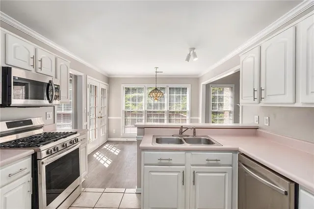 a kitchen with stainless steel appliances granite countertop a sink stove and cabinets