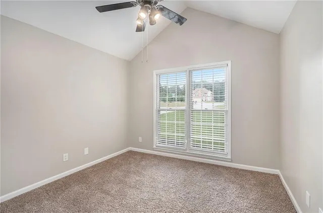 an empty room with chandelier fan