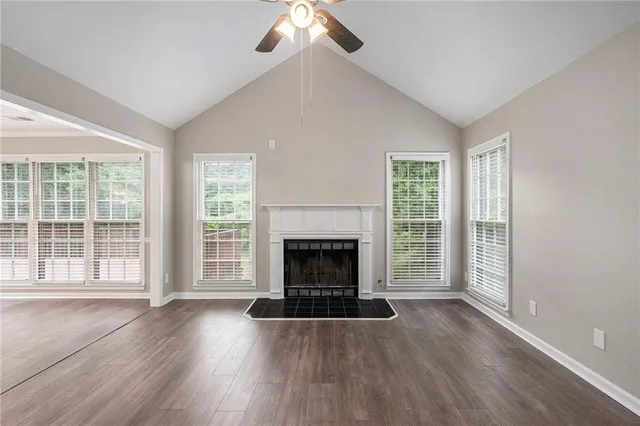 wooden floor fireplace and windows in an empty room