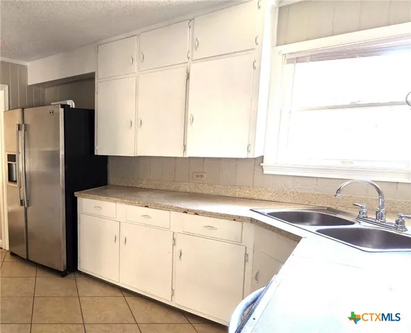 a kitchen with a sink a refrigerator and window