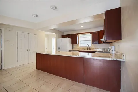 a kitchen with a sink a refrigerator and cabinets