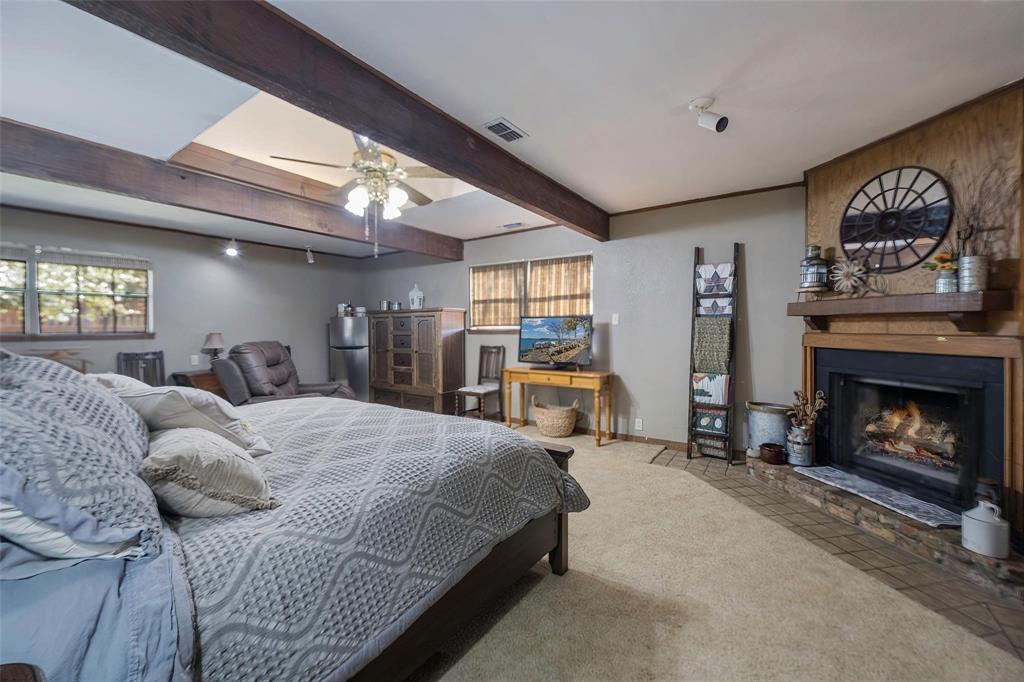 236 County Road 1422 Quitman, TX 75783 - Photo 11 of 34 Bedroom featuring carpet, beam ceiling, a fireplace, visible vents, and baseboards