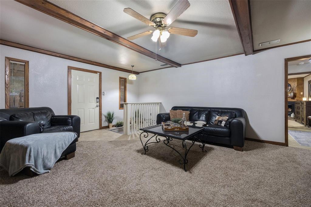 236 County Road 1422 Quitman, TX 75783 - Photo 6 of 34 Carpeted living room featuring ceiling fan, beam ceiling, and baseboards