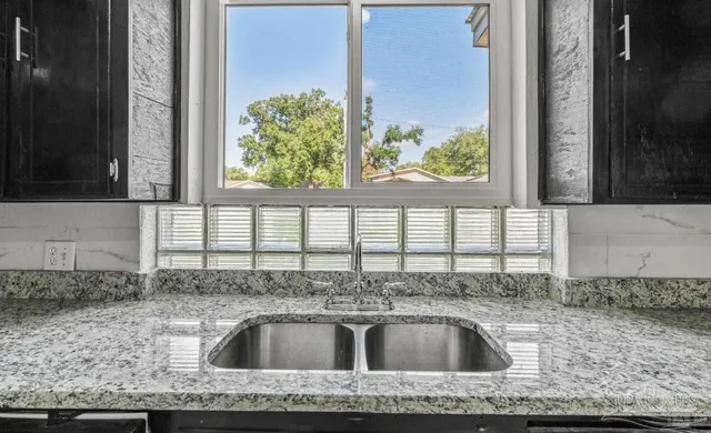 a kitchen with stainless steel appliances granite countertop a refrigerator a sink dishwasher a stove and a refrigerator