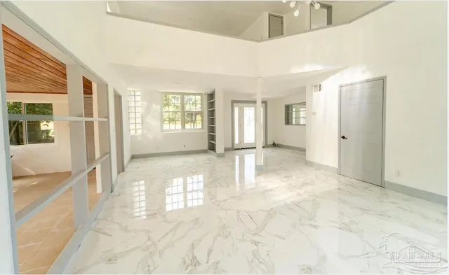 a view of a big room with windows and chandelier fan