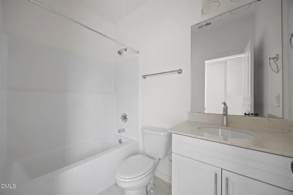 a bathroom with a toilet sink vanity and mirror
