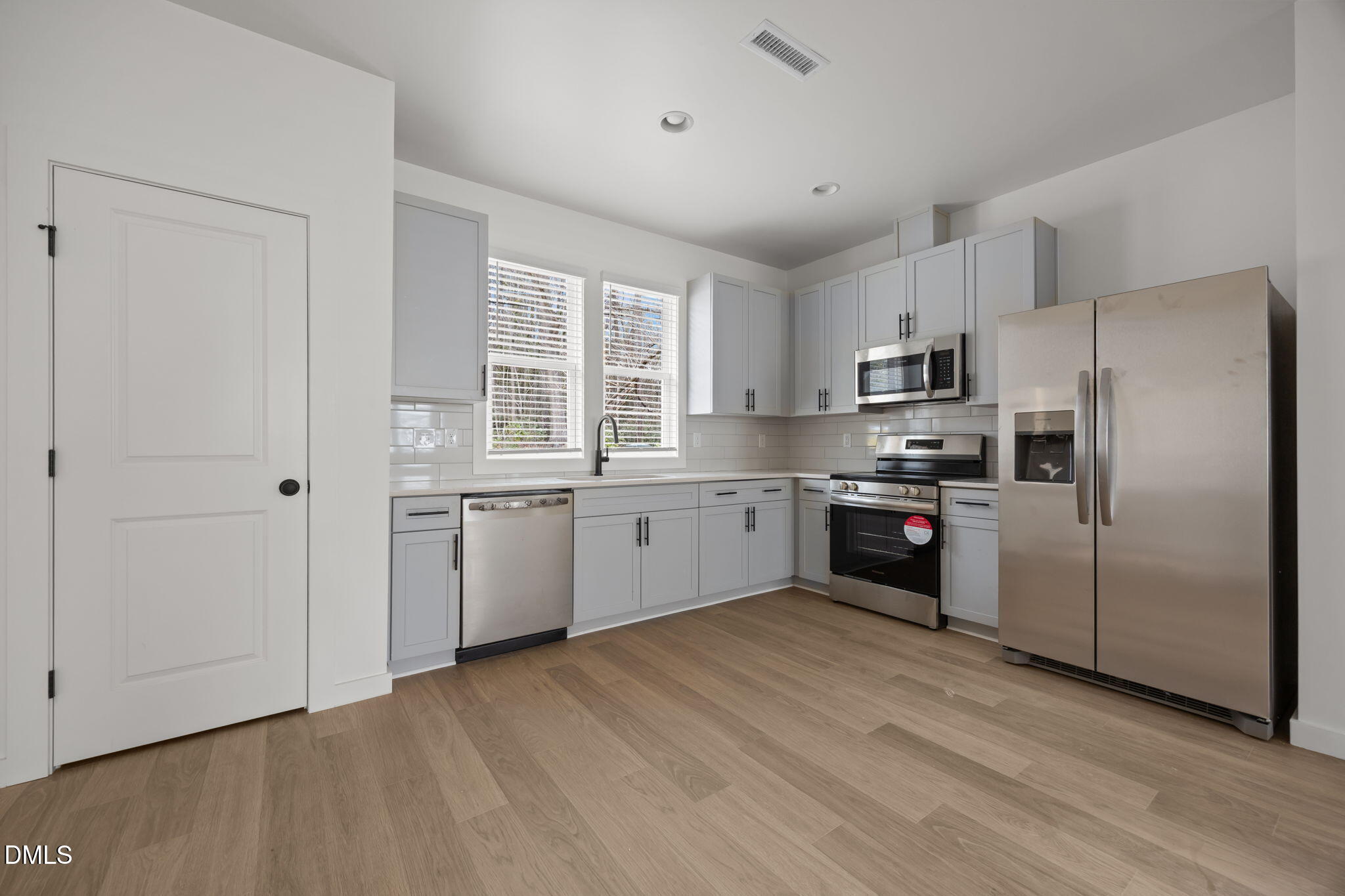 2811 Wilcox Place, Unit 101 Raleigh, NC 27607 - Photo 20 of 29 a kitchen with stainless steel appliances a refrigerator sink and cabinets