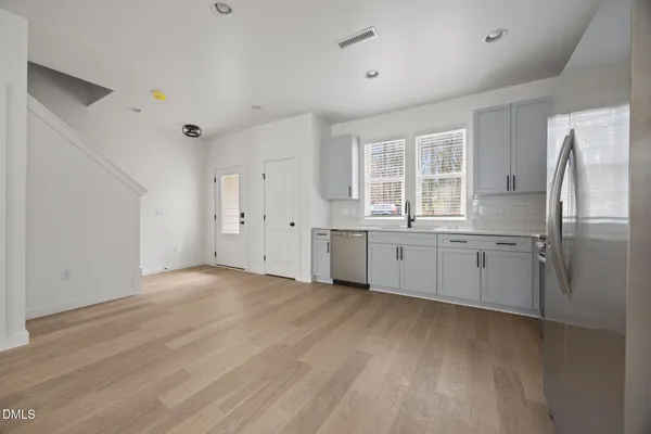 a kitchen with stainless steel appliances a refrigerator sink and cabinets