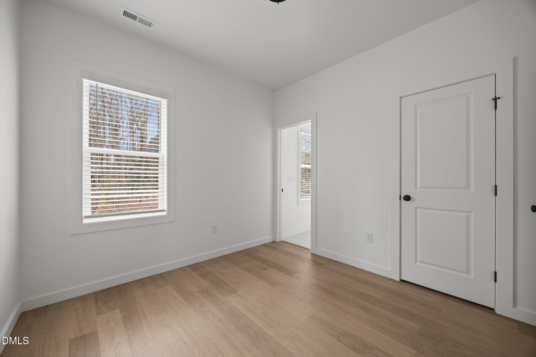 2811 Wilcox Place, Unit 101 Raleigh, NC 27607 - Photo 5 of 29 a view of an empty room with wooden floor and a window