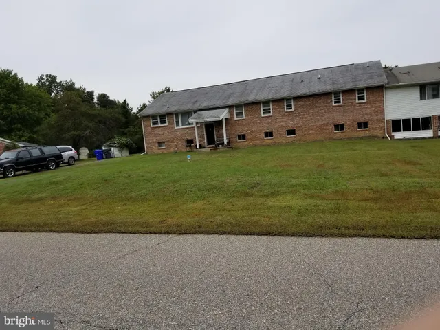 a front view of a house with a garden and trees