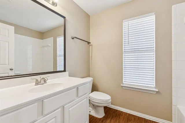 a bathroom with a granite countertop sink toilet and mirror