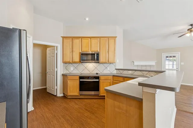 a kitchen with stainless steel appliances granite countertop a sink and a stove top oven