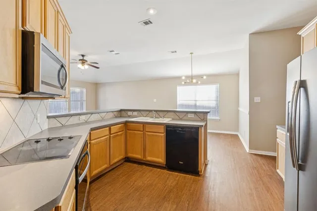 a kitchen with stainless steel appliances granite countertop a sink a stove and a refrigerator