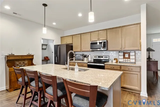 a kitchen with granite countertop a stove a refrigerator a microwave oven a stove a dining table and chairs