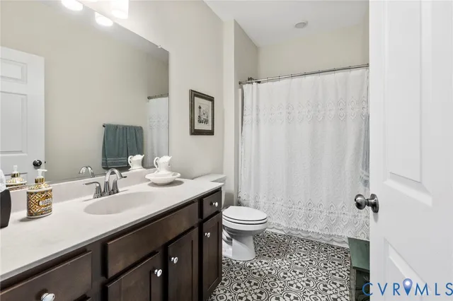 a bathroom with a sink a toilet a mirror and shower