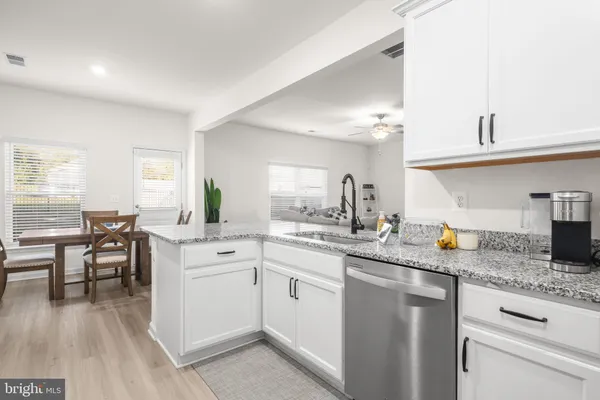 a kitchen with stainless steel appliances granite countertop a sink stove and cabinets
