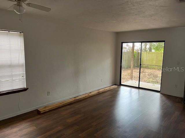 1712 Southwest 67th Terrace Gainesville, FL 32607 - Photo 4 of 10 an empty room with wooden floor and windows with curtains