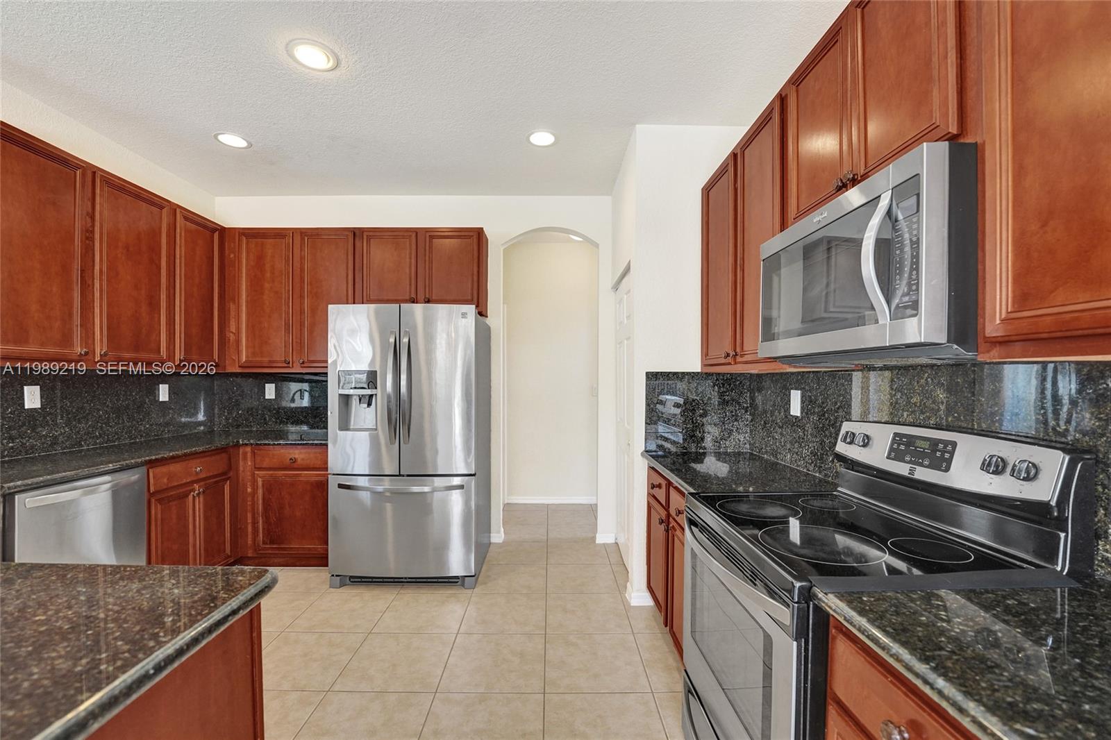3936 Cascade Terrace Weston, FL 33332 - Photo 26 of 90 a kitchen with granite countertop a refrigerator stove and microwave