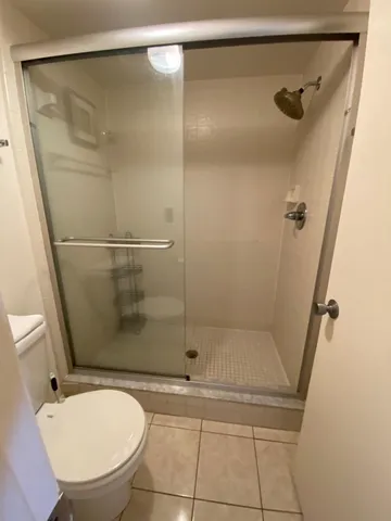 a bathroom with a sink a toilet a mirror and shower