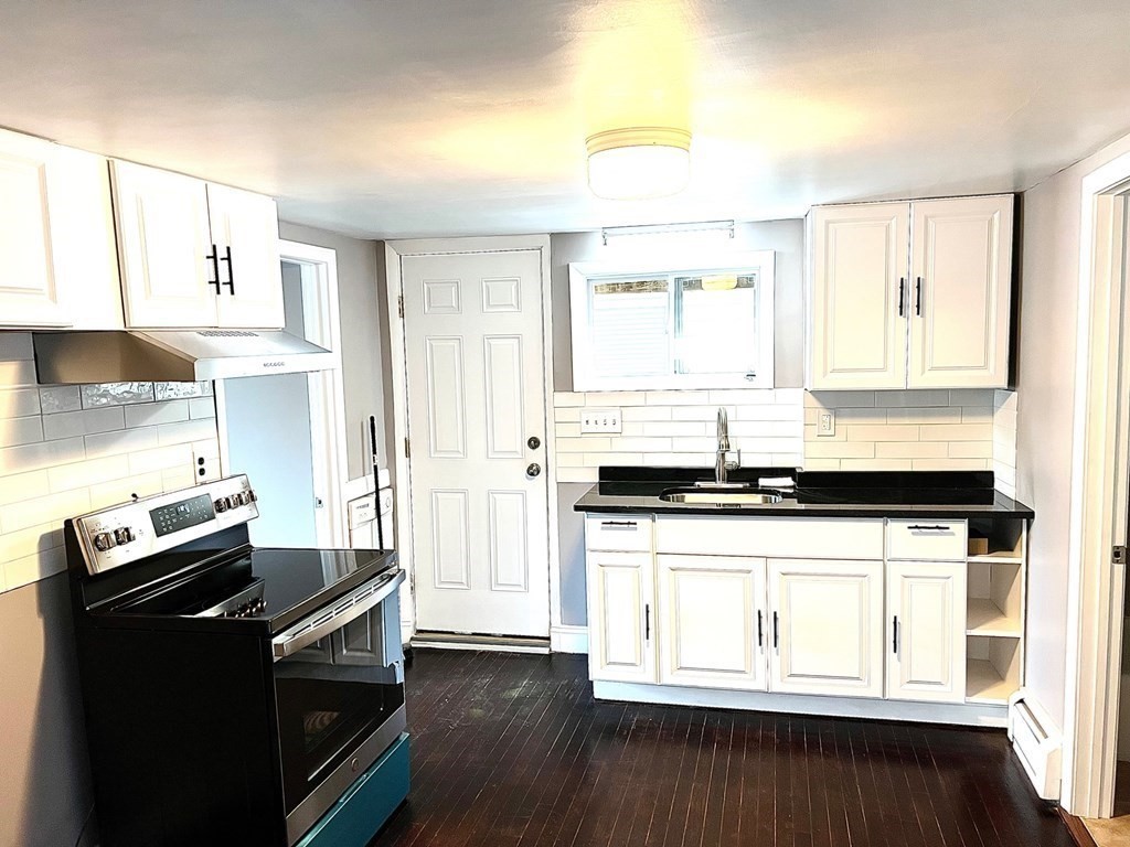 150 Locust Street, Unit 1 Winthrop, MA 02152 - Photo 4 of 11 a kitchen with stainless steel appliances granite countertop a stove and a microwave