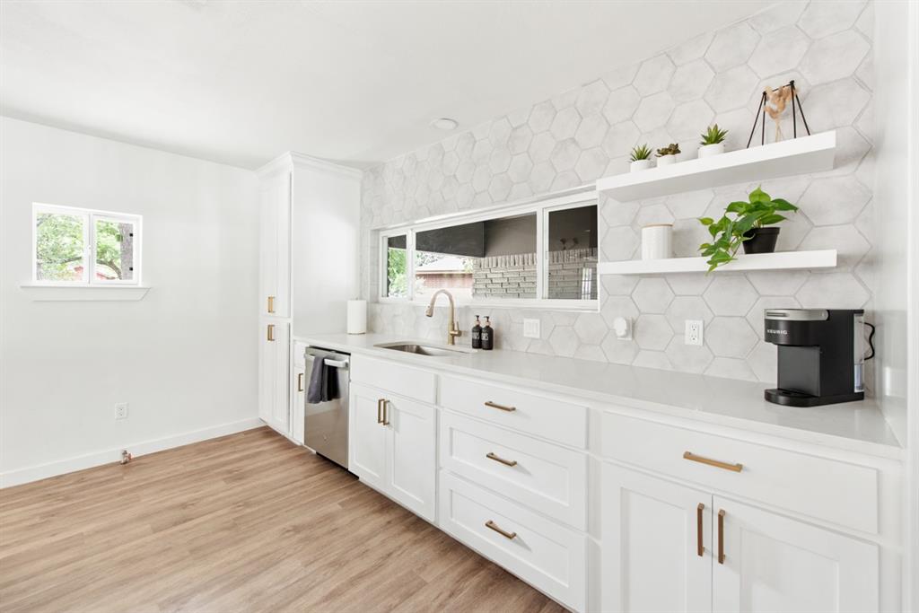 4252 McComas Road Haltom City, TX 76117 - Photo 17 of 35 a kitchen with stainless steel appliances white cabinets and wooden floor