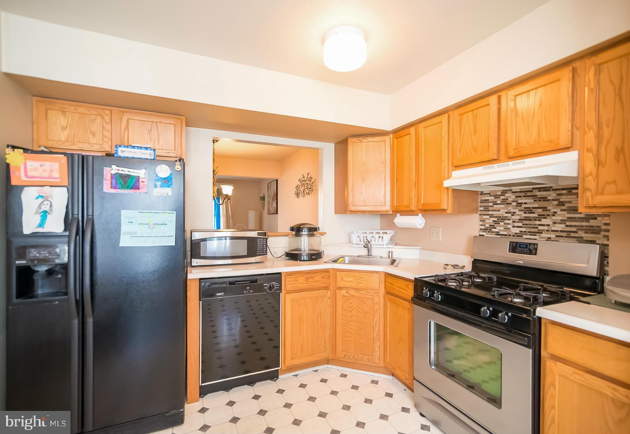 631 Hunting Fields Road Baltimore, MD 21220 - Photo 12 of 29 a kitchen with stainless steel appliances a stove a sink and a refrigerator