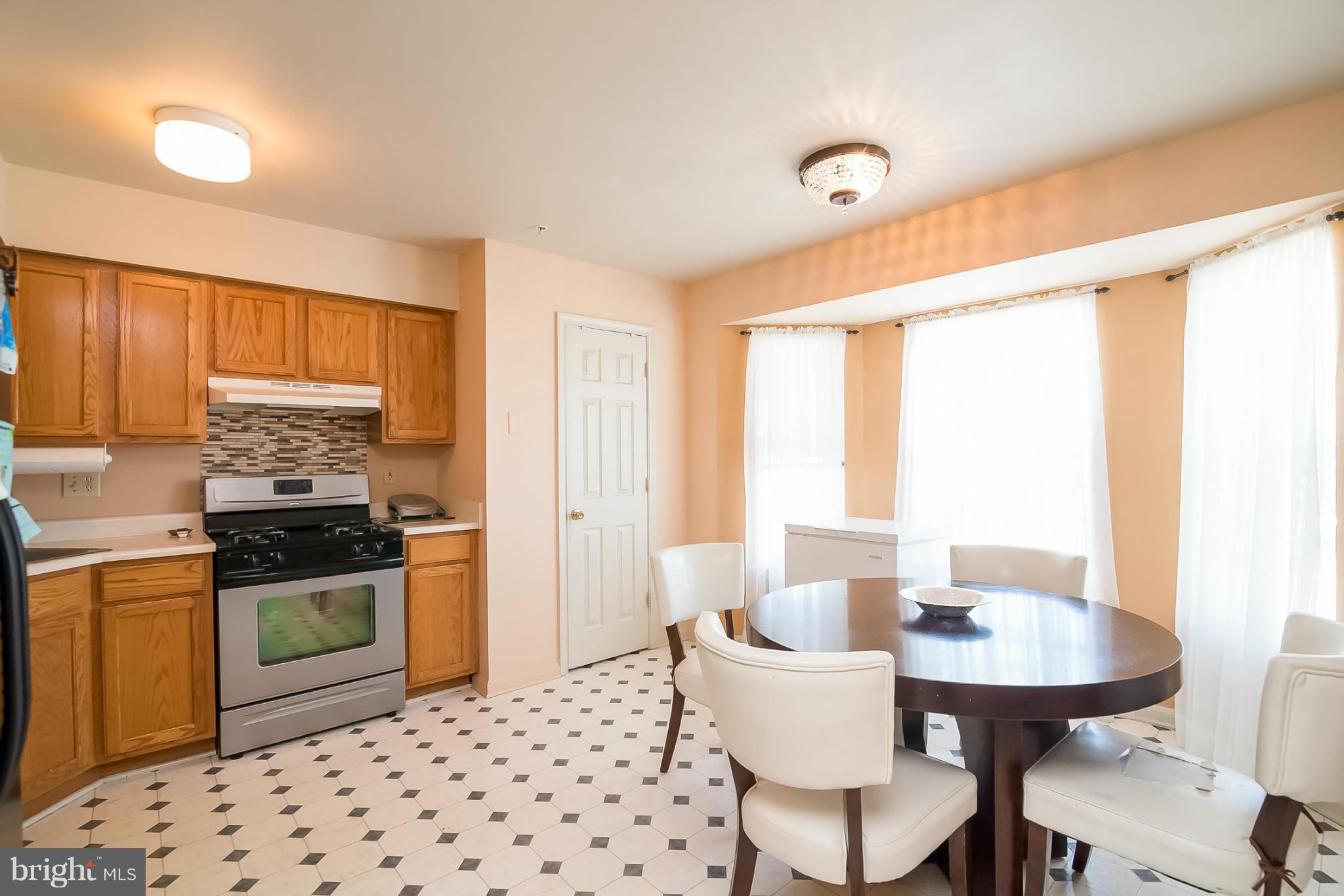 631 Hunting Fields Road Baltimore, MD 21220 - Photo 14 of 29 a kitchen with a stove a sink a dining table and chairs