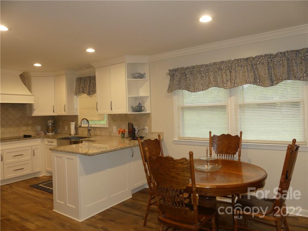 1319 Mooresboro Road Shelby, NC 28150 - Photo 11 of 27 a kitchen with a dining table chairs and white cabinets